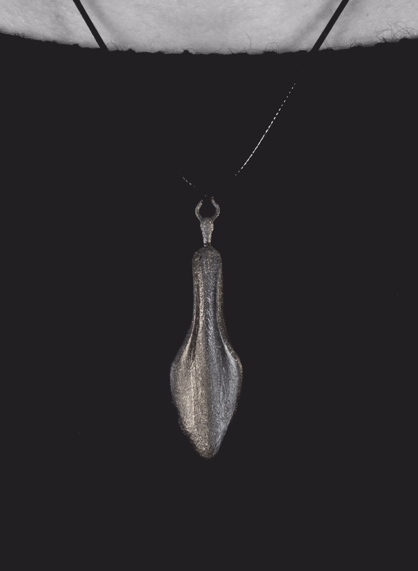 Chaos hanging on its cord against a black top
