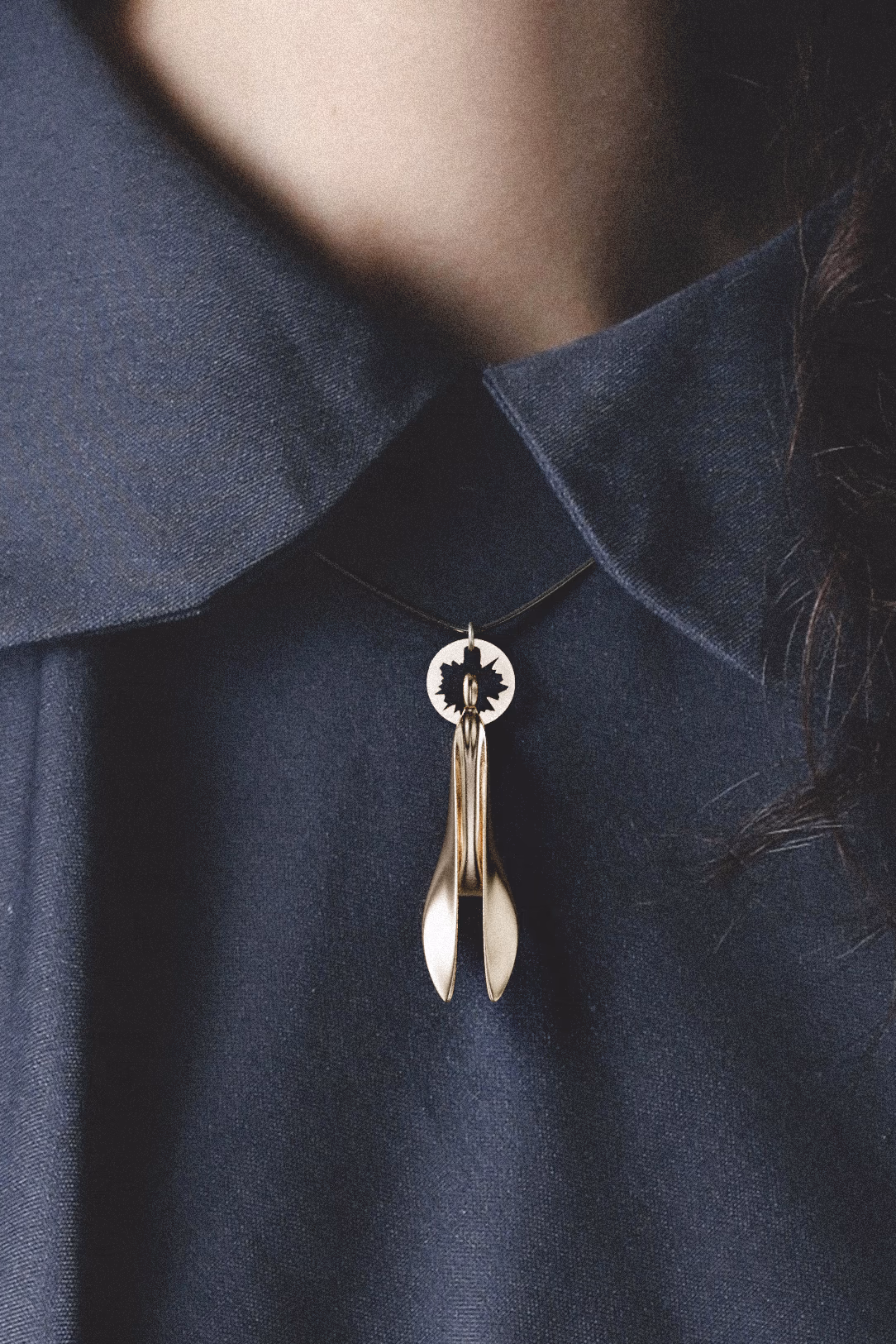 Silence worn at the collar of a navy shirt